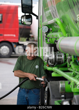 Camionneur de remplir son camion avec cher carburant diesel Hazeldonk Dutch frontière Belge Banque D'Images