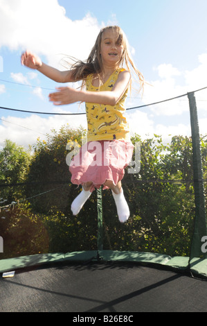 Une fillette de dix ans, de sauter sur un trampoline Banque D'Images