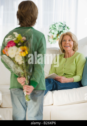 Petit-fils d'étonnant Grand-mère avec des fleurs Banque D'Images