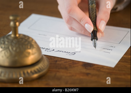 Femme remplissant la réservation de l'hôtel Banque D'Images