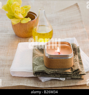 Bougie allumée en face de la fleur et de l'huile de bain Banque D'Images