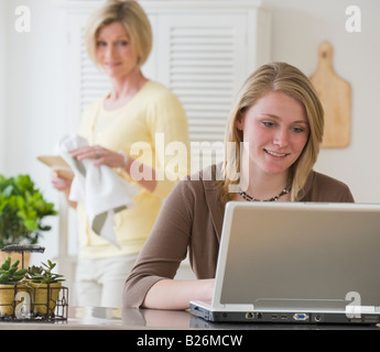 Mère regardant fille adolescente saisie sur ordinateur Banque D'Images