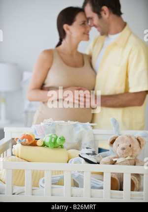 Pregnant Hispanic couple hugging Banque D'Images