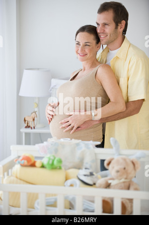 Pregnant Hispanic couple hugging Banque D'Images