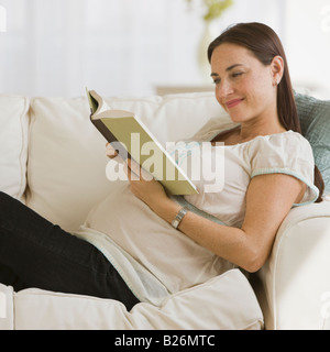 Pregnant Hispanic woman reading book Banque D'Images