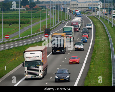 Longue file de camions roulant sur l'A16 E19 route d'Anvers à la frontière belge Néerlandais Pays-Bas Hazeldonk Banque D'Images