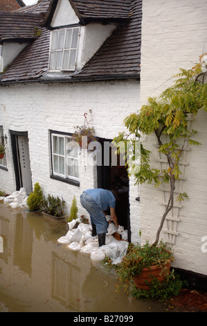 Un résident de ce pays d'INONDATION TEWKESBURY GLOUCESTERSHIRE BARRICADES LA PORTE D'UN CHALET AVEC DES SACS DE JUILLET 2007 UK Banque D'Images