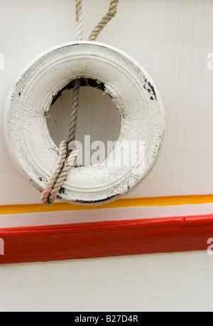 Une image de l'art graphique du côté d'un bateau blanc peint avec un pneu sur une corde pend plus tourné en Newquay Cornwall en Angleterre Banque D'Images