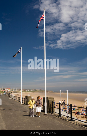 UK de Tyne et Wear Sunderland Seaburn les personnes âgées à marcher le long de la promenade de la baie à Whitburn aux beaux jours d'été Banque D'Images