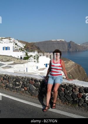 Smiling miiddle âge femme'appréciant les sites incroyables sur la caldeira à Oia, Santorin, Cyclades, en Grèce. Banque D'Images