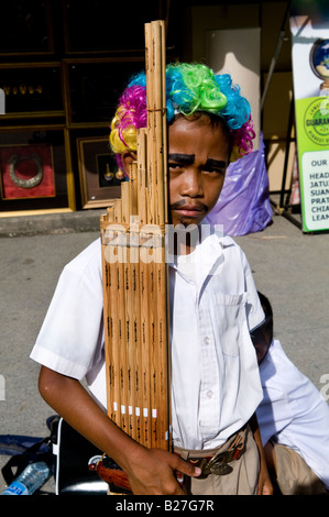 Un jeune garçon thaï joue un flûte traditionnelle dans le marché de Chatuchak week-end à Bangkok,Thaïlande , Banque D'Images