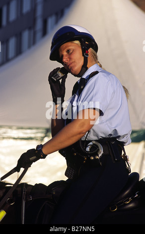 Femme de la Police à cheval en conversation sur son téléphone mobile. Amsterdam, Pays-Bas. Banque D'Images