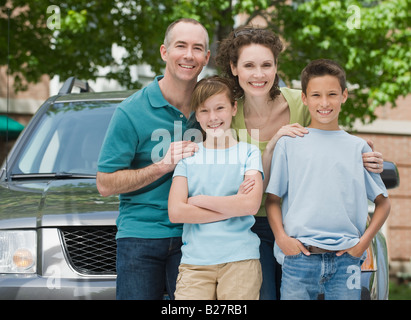 Famille avec deux enfants en face de voiture Banque D'Images