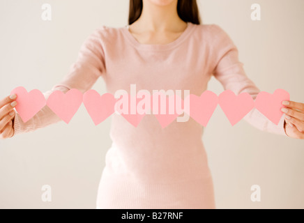 Woman holding string de découper des cœurs Banque D'Images