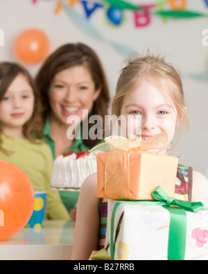 Girl holding pile de cadeaux d'anniversaire Banque D'Images