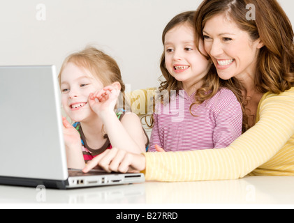 Mère et filles looking at laptop Banque D'Images