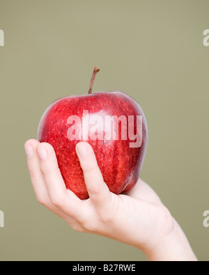 Close up of child holding apple Banque D'Images