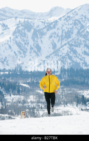 Woman running in snow Banque D'Images
