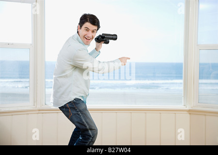 Homme pointant et holding binoculars Banque D'Images