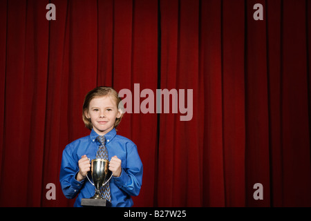 Boy holding trophy sur scène Banque D'Images