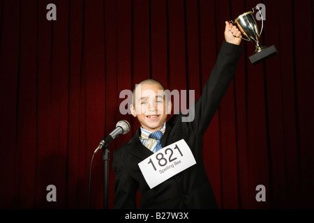 Boy wearing nombre et holding trophy Banque D'Images