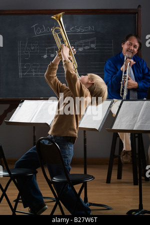 Boy playing Trumpet in classroom Banque D'Images