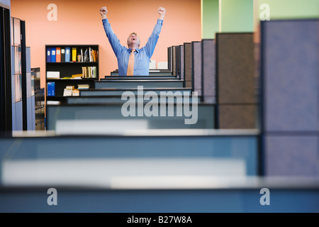 Businessman cheering in cubicle Banque D'Images