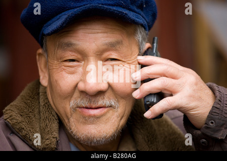 Chinese man discussions sur un téléphone mobile Fuli Vieille Ville Xingping Chine Banque D'Images
