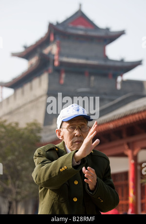 Les pratiques de l'homme de Tai chi dans le cadre de ses exercices matinaux dans le parc par le mur de la ville de Xian Chine Banque D'Images