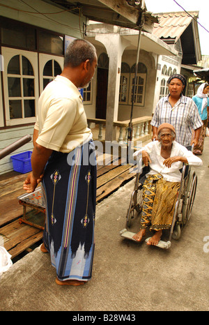 Vieille dame en fauteuil roulant , Muslim village flottant, l'île de Koh Panyi, Ao Phang Nga , Phuket , Thaïlande Banque D'Images