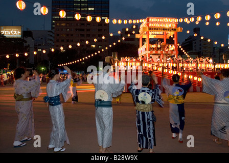 Les danseurs vêtus de Kimono pour former un anneau autour de la lanterne décorée tour du tambour lors d'une soirée d'événement à Tokyo Bon Odori Banque D'Images