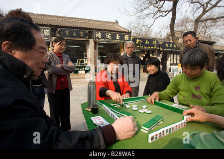 Les gens se rassemblent pour jouer mahjong dans le parc par le mur de la ville Xian Chine Banque D'Images