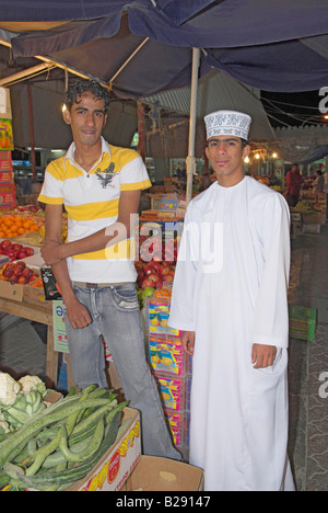 Deux hommes omanais vente de fruits et légumes dans le souk près de Seeb Muscat Oman Banque D'Images