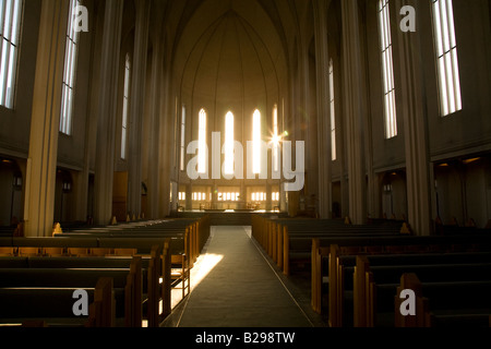 Un faible soleil brille à travers la fenêtre de l'est dans la nef de l'église de Hallgrimur Reykjavik Islande Banque D'Images