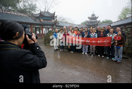 Les visiteurs de navire de croisière Yangtze posent pour une photographie avec guide à la ville de Fengdu fantômes en Chine Banque D'Images