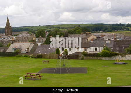 Aire de jeux avec balançoires enfant vide et rond-point de parc avec en arrière-plan La ville de Kirkcudbright Dumfries et Galloway Ecosse Banque D'Images