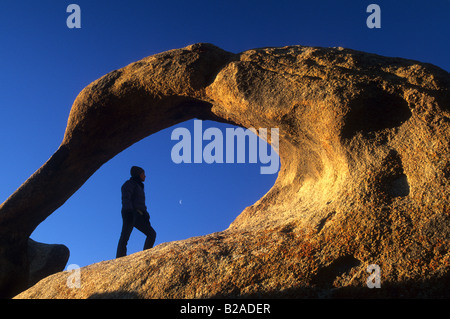 Randonneur dans une arche naturelle de Mobius, Alabama Hills, Californie Banque D'Images