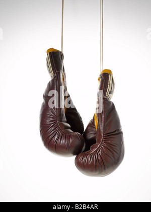 Paire de gants de boxe en cuir marron vintage avec cordes suspendues Banque D'Images