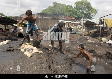 De nombreux habitants des bidonvilles vivent de recyclage des déchets industriels. Laver les scories industrielles travaillent à la journée à la recherche de résidus de métal. Les jeunes m Banque D'Images