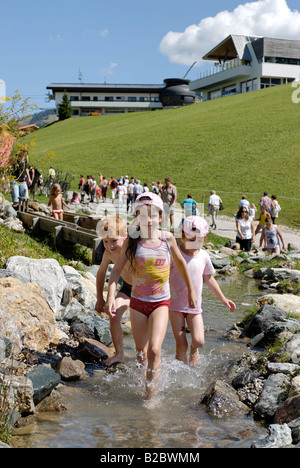 Les enfants des éclaboussures dans l'eau du Sentier pieds nus au Hexenwasser près de Mt. Hohe Salve, Soell, Tyrol, Autriche, Europe Banque D'Images