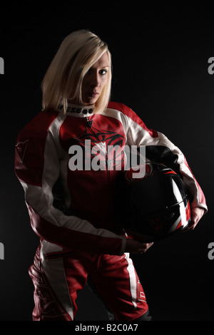 Femme blonde portant un costume holding un casque de moto sous le bras Banque D'Images