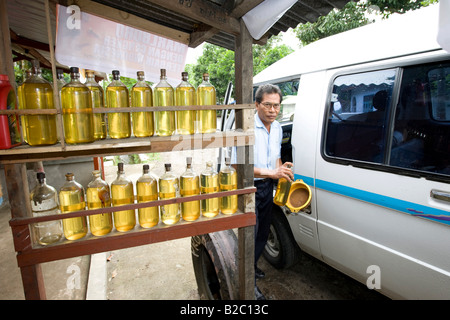 Station typique de l'Asie, de l'essence stockée dans des bouteilles en verre, car alimentée à partir de bouteilles en verre, de l'île Lombok, îles de la sonde Banque D'Images