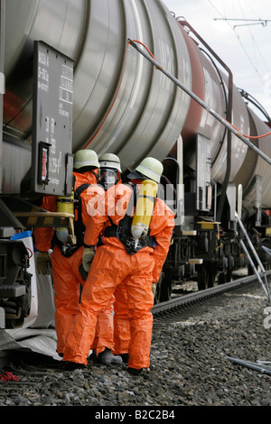 Pompiers portant des combinaisons de matières dangereuses au travail pendant une catastrophe, près de forage de Poing, Bavaria, Germany, Europe Banque D'Images