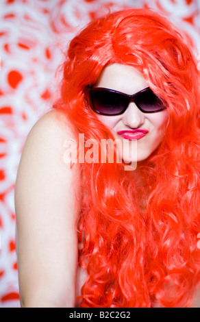 Portrai d'une femme avec une perruque et des lunettes de soleil rouge Banque D'Images