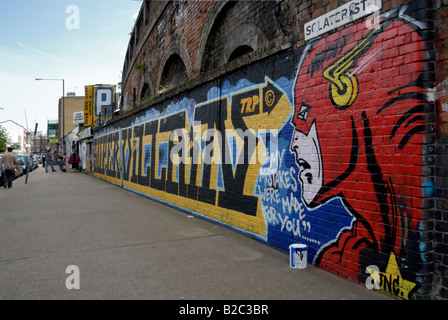 Fresque sur mur avec les gens sur le trottoir, Londres Banque D'Images