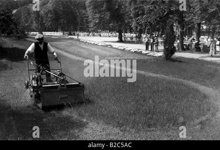 Man mowing lawn, photo historique d'environ 1920 Banque D'Images