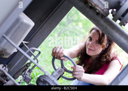 Jeune femme avec une roue tournant haut rose Banque D'Images