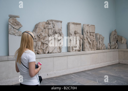 Un visiteur à la recherche de reliques de la Grèce antique et portant des écouteurs audio guide pour la visite de système Musée Pergamon de Museumsinsel Berlin Allemagne île Banque D'Images