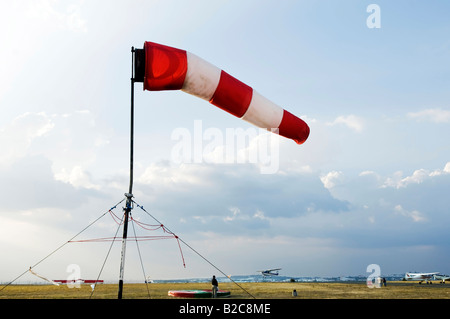 Une manche rouge et blanc volant dans le vent pour la direction du signal sur un aérodrome Banque D'Images