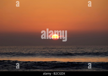 Coucher de soleil rouge sur les eaux de l'océan calme Banque D'Images